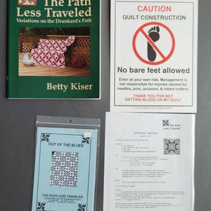 May include: Four quilting pattern books with a green, blue, and white color scheme. The books are titled "The Path Less Traveled: Variations on the Drunkard's Path", "Out of the Blues", "Daffodil Dazzle", and "The Path Less Traveled".
