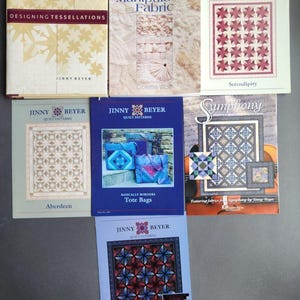 May include: A collection of quilting pattern books by Jinny Beyer. The books feature various quilt designs, including "Aberdeen", "Serendipity", "Symphony", "Tote Bags", and "Sumatra".
