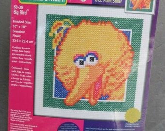 May include: A counted cross stitch kit featuring Big Bird from Sesame Street. The kit includes a 10-inch by 10-inch Aida fabric, pre-sorted floss, a needle, and instructions. The finished product will be a yellow Big Bird with orange beak and blue eyes.