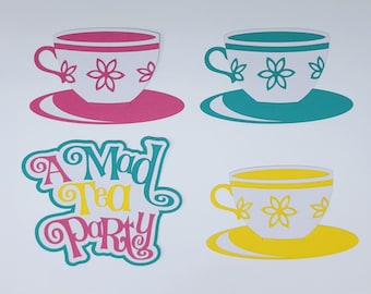 May include: A Mad Tea Party themed set of three paper teacups and saucers. The teacups are white with pink, teal and yellow accents and floral designs. The saucers are the same colours as the teacups. The text "A Mad Tea Party" is written in a whimsical font.