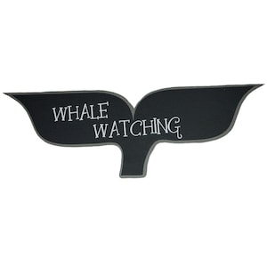 May include: Black chalkboard whale tail sign with the text "Whale Watching" in white.