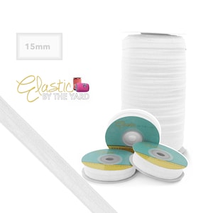 K&ouml;nnte beinhalten: Wei&szlig;es Gummiband, 15 mm breit, auf einer Spule gewickelt. Das Gummiband ist in einer Nahaufnahme und auch als durchgehende L&auml;nge dargestellt.