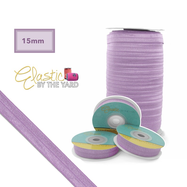 May include: A spool of 15mm wide lavender elastic, with the brand name "Elastic by the Yard" printed on the spool. The elastic is wound around a white cardboard tube.