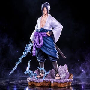 May include: A detailed anime-style figurine of a male character with spiky dark hair, wearing a white open-front top, dark blue pants, and a thick purple rope belt. The figure holds a translucent blue jagged sword and stands on a rocky base.