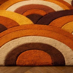 Handmade retro rainbow arch tufted area rug featuring geometric mid century modern design in burnt orange, mustard yellow, cream, and brown tones for boho living room decor.