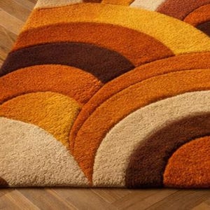 Handmade retro rainbow arch tufted area rug featuring geometric mid century modern design in burnt orange, mustard yellow, cream, and brown tones for boho living room decor.
