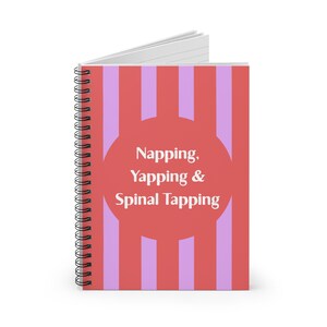 Może przedstawiać: Spiralny notatnik z czerwoną i liliową okładką w paski. Okładka posiada czerwone koło z białym napisem "Napping, Yapping & Spinal Tapping". Notatnik ma białe strony i srebrną spiralną oprawę.
