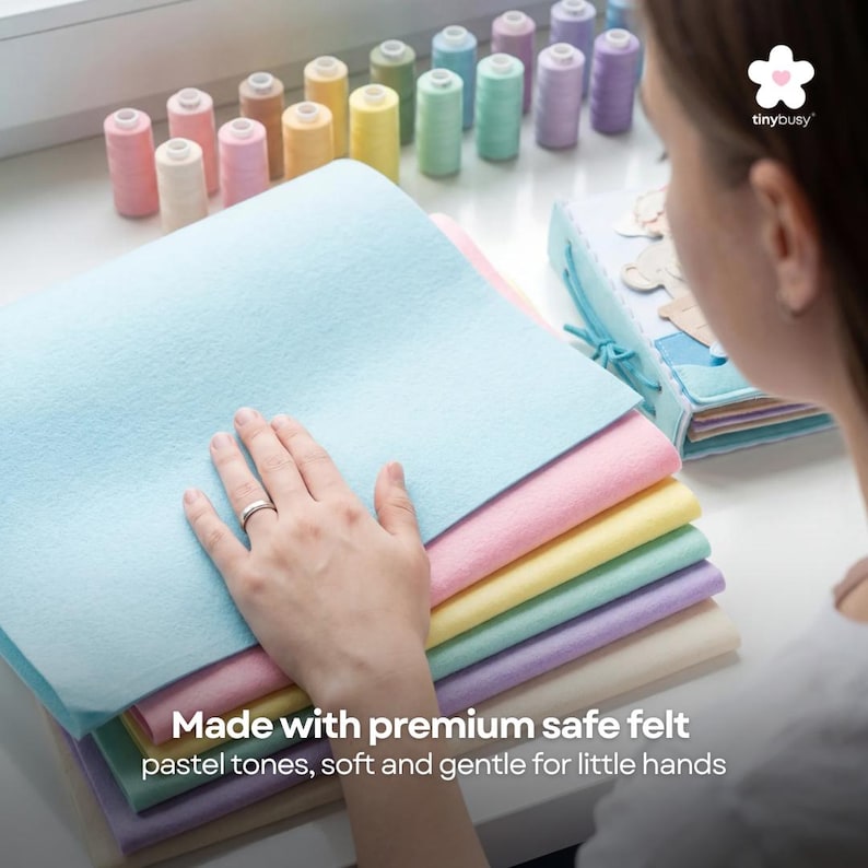 Pu&ograve; includere: Una pila di fogli di feltro dai colori pastello in blu, rosa, giallo, verde e viola. Il testo "Made with premium safe felt, pastel tones, soft and gentle for little hands" &egrave; visibile. Sbobine di filo di vari colori pastello sullo sfondo.