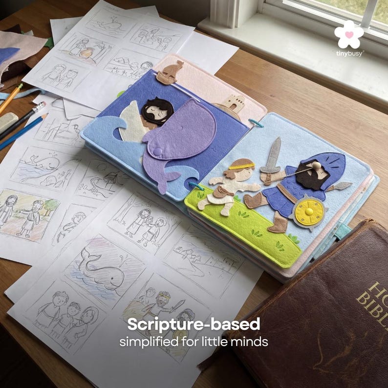 Pu&ograve; includere: Un libro di feltro colorato con illustrazioni di storie bibliche, aperto su una pagina con una balena viola e onde blu. Il libro &egrave; circondato da schizzi e una Bibbia rilegata in pelle marrone. Il testo sull'immagine recita "Scripture-based simplified for little minds."