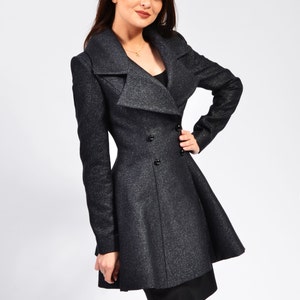 Three-quarter front view of a fitted wool coat with wide lapels, double-breasted buttons, and a flared hem