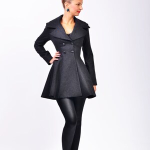 Full front view showing the coat's fitted waist, wide lapels, long sleeves, and double-breasted buttons