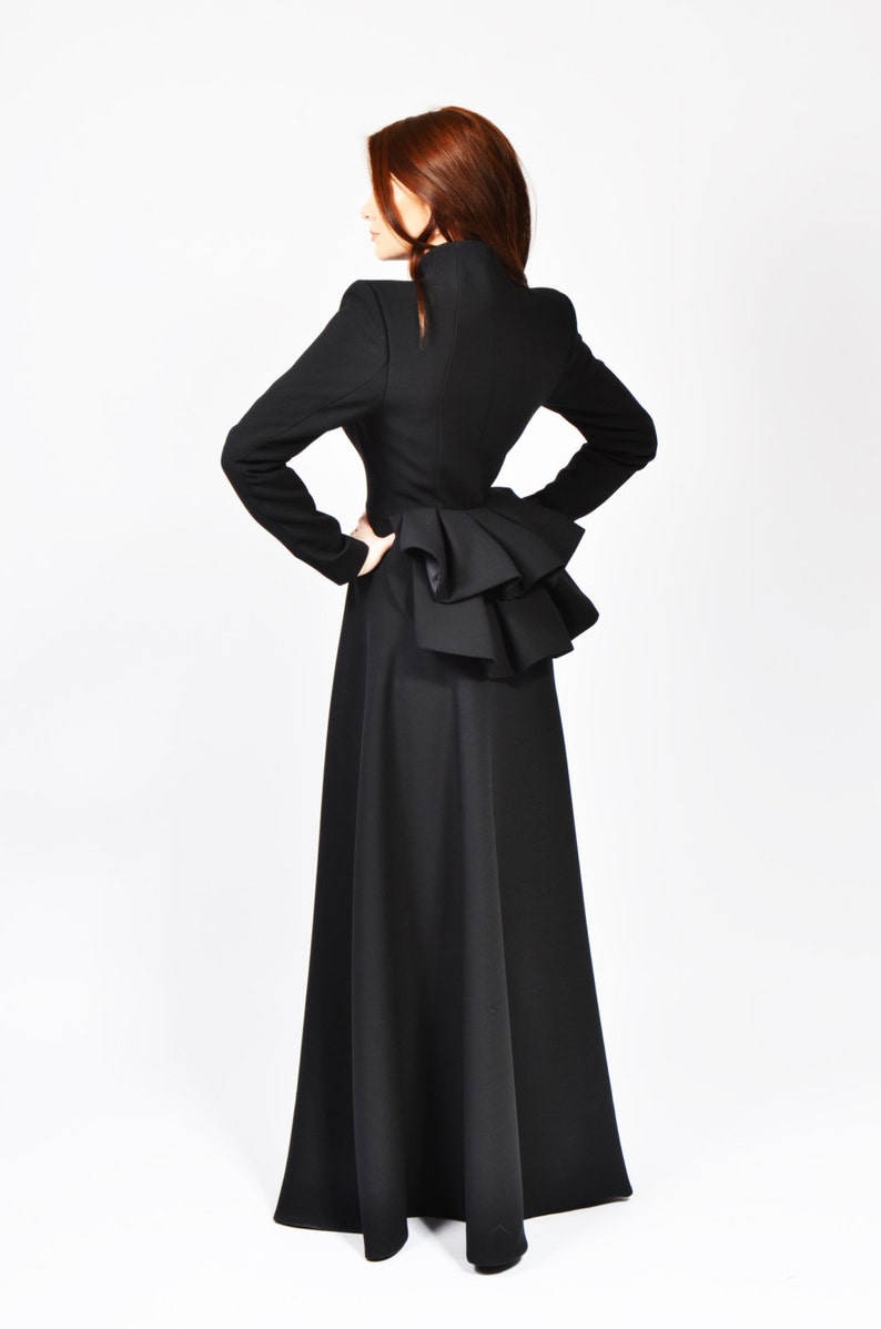 May include: A black long-sleeved dress with a ruffled detail at the back.