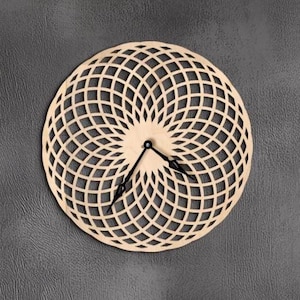 Puede incluir: Un reloj de pared redondo de madera con un diseño geométrico. El reloj tiene un acabado marrón claro y manecillas negras. Está montado en una pared gris oscuro. Debajo del reloj se ven jarrones decorativos y una planta en maceta.