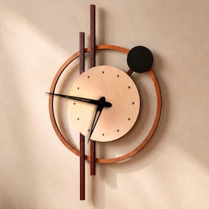 May include: A wall clock featuring a circular frame and vertical wooden slats in alder, cherry, natural, and wenge tones. The clock face is a light natural wood circle with black hands and a small black circular accent at the top right corner.