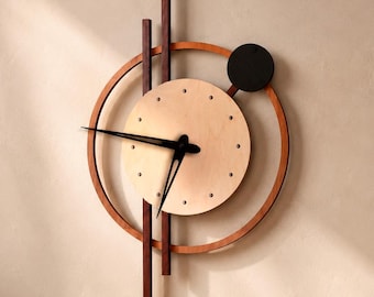 Puede incluir: Un reloj de pared con un marco circular y listones de madera verticales en tonos aliso, cerezo, natural y wengué. La esfera es un círculo de madera clara con manecillas negras y un pequeño acento circular negro en la esquina superior derecha.