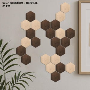 Puede incluir: Una decoración mural con 24 baldosas hexagonales de madera en colores castaño y natural. Las baldosas están dispuestas en un patrón contra una pared gris. El texto "Color: CHESTNUT + NATURAL" y "24 pcs" es visible.