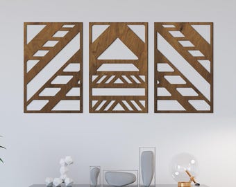 May include: Three walnut-colored wooden wall panels with geometric cut-out designs. Each panel is rectangular with a unique pattern of diagonal lines, triangles, and horizontal bars. The panels are mounted on a white wall.