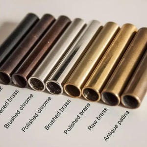 May include: An assortment of metal tubes in various finishes, including matte black, antique black, blackened brass, brushed chrome, polished chrome, brushed brass, polished brass, raw brass, and antique patina. The text labels each finish.