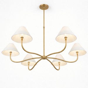 May include: A gold-toned chandelier with six white fabric shades. The light fixture has a central stem and curved arms extending to hold the shades. The shades are cone-shaped, and the fixture is against a white background.