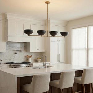 May include: A linear chandelier featuring a thin, horizontal brass rod suspended from the ceiling by a single vertical stem. The fixture holds four matte black, bowl-shaped shades arranged in a row, providing downward-facing illumination.