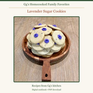 May include: A stack of round, light-colored sugar cookies with small purple flower-shaped icing decorations, served on a round wooden serving board with a handle. The text reads Gg's Homecooked Family Favorites, Lavender Sugar Cookies, Recipes from Gg's kitchen, Digital cookbook &bull; PDF download.