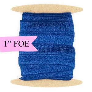 May include: A spool of 1" wide blue fold over elastic (FOE) on a wooden dowel.