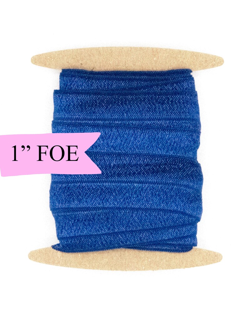 May include: A spool of 1" wide blue fold over elastic (FOE) on a wooden dowel.