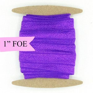 May include: A spool of 1" purple fold over elastic (FOE) on a wooden dowel.