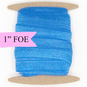 May include: A spool of 1" blue fold over elastic (FOE) on a wooden dowel.
