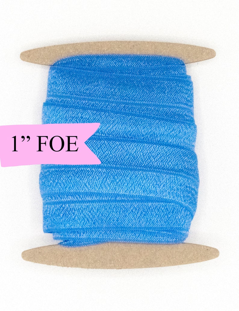 May include: A spool of 1" blue fold over elastic (FOE) on a wooden dowel.