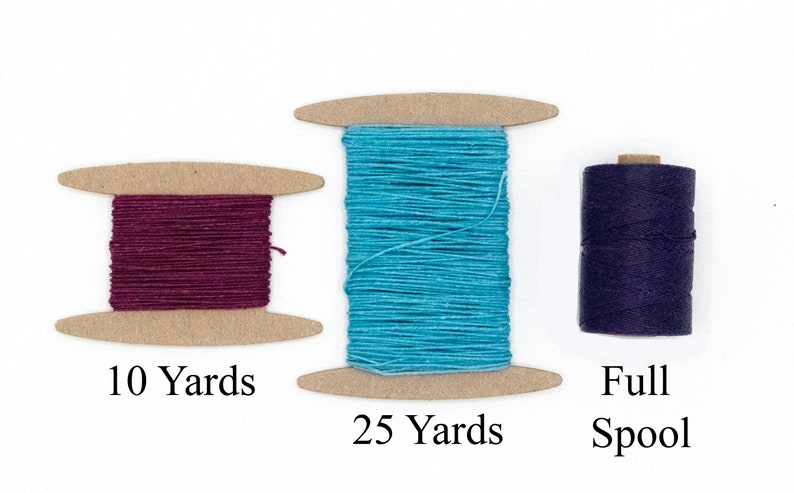 May include: Three spools of thread in varying colors. One spool is a deep burgundy with "10 Yards" printed below. The second spool is turquoise with "25 Yards" printed below. The third spool is dark blue with "Full Spool" printed below.