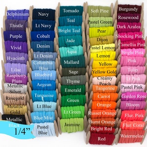 May include: A collection of 1/4 inch wide elastic bands in a variety of colours, including teal, purple, pink, green, orange, and red. The elastic bands are arranged in rows and labelled with their corresponding colour names.