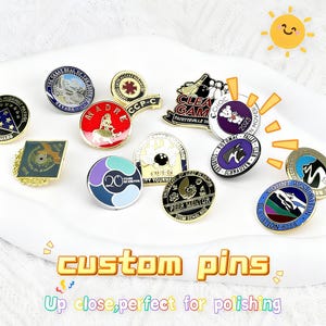 Puede incluir: Una colección de pines personalizados con varios diseños y colores. Algunos pines presentan texto, logotipos e ilustraciones. Los pines son redondos y ovalados, con un acabado brillante. El texto "custom pins" se muestra en la parte inferior.