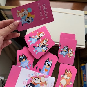 Pode incluir: Cartões de convite rosa para festas com personagens de desenhos animados. Um cartão diz "Valentina Is Turning 5". Outros cartões exibem várias ilustrações de personagens. Os cartões são para uma festa de aniversário infantil.