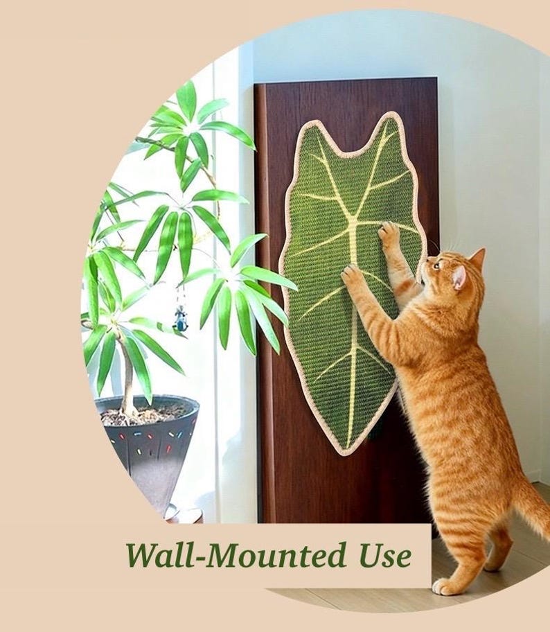 May include: A green leaf-shaped cat scratcher is mounted on a wooden door. The scratcher has a beige border and a cat is shown using it. The text "Wall-Mounted Use" is at the bottom of the image.