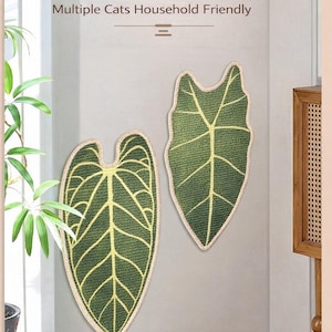 May include: Two green leaf-shaped decorative items with yellow vein details and a beige border are displayed on a wall. The text "Pair Together Use" and other phrases are visible. The items are likely for home decor.