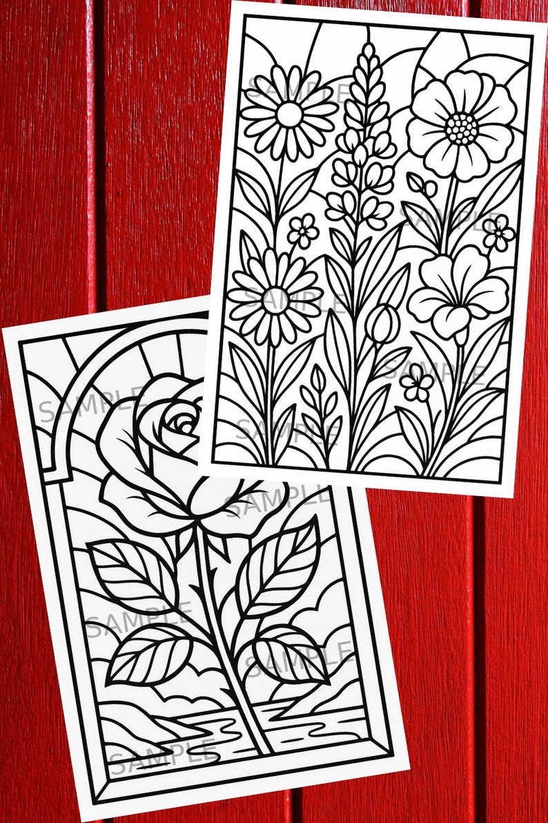 May include: Two black and white floral coloring pages. One features a rose in a stained glass window design. The other has a variety of flowers and foliage. The pages are on a red wooden surface.