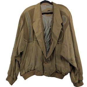 May include: A vintage tan jacket with a unique design, featuring a wide collar and decorative panels. The jacket has a button closure and ribbed cuffs and hem. The label reads "Michael Jordan".