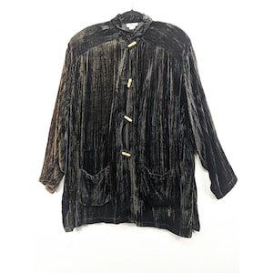 May include: A dark brown velvet jacket with a mandarin collar, long sleeves, and two front pockets. The jacket features three wooden toggle closures and is hanging on a black hanger.