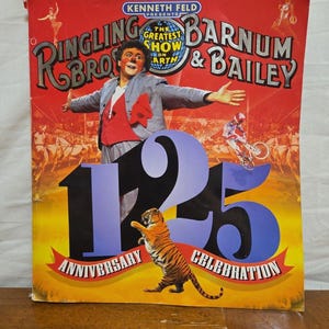 May include: A vintage Ringling Bros. and Barnum & Bailey Circus program cover. The cover features a clown, a tiger, and the text "125th Anniversary Celebration". The background is red with circus performers.