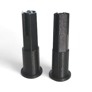 May include: Two black, cylindrical objects with a flared base and a ridged top. The objects are standing upright against a white background. The objects appear to be made of plastic.