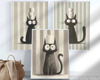 May include: Three framed wall art prints featuring black cats with wide eyes against vertical striped backgrounds. Two cats balance stacks of toilet paper rolls on their heads, while the third cat balances a single roll on its head.
