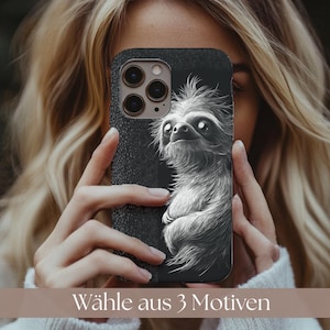May include: A black phone case featuring a detailed grayscale illustration of a sloth. The case is held up in front of a person. The text "Wähle aus 3 Motiven" is at the bottom of the image.