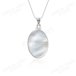 May include: A silver necklace with an oval, iridescent pendant. The pendant has a mother-of-pearl appearance and is set in a silver frame. The necklace is displayed on a white background.