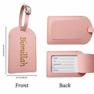 May include: A pink luggage tag with a buckle and strap, measuring 4.3 inches (11.0 cm) in height and 2.7 inches (6.8 cm) in width. The front features the gold text "Bismillah". The back has a slot for a name, telephone, address, and email.