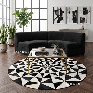May include: A modern living room featuring a black sectional sofa, a glass-top coffee table with a gold frame, and a round black and white geometric rug. Decorative plants and abstract art pieces complete the stylish interior.