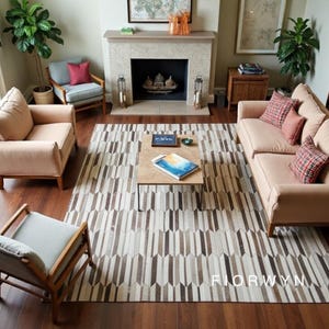 Könnte beinhalten: Ein Wohnzimmer mit einem hellfarbigen Sofa und Sesseln, einem gemusterten Teppich in Braun- und Cremetönen und einem Couchtisch. Im Hintergrund ist ein Kamin zu sehen, der eine gemütliche Atmosphäre schafft.