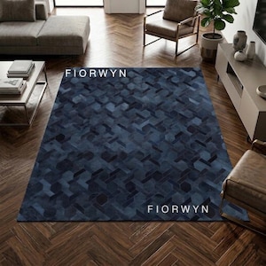 Könnte beinhalten: Ein rechteckiger blauer Teppich mit einem geometrischen Muster aus ineinandergreifenden Formen. Der Teppich hat eine dunkelblaue Farbpalette mit hellblauen Akzenten. Das Wort "FIORWYN" ist weiß auf dem Teppich aufgedruckt.