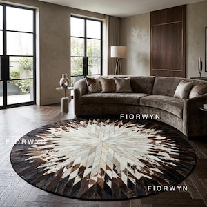 Può includere: Un tappeto rotondo con un motivo geometrico a stella nei toni del marrone, crema e nero. Il tappeto è realizzato con un patchwork di pelle o pelle. La parola "FIORWYN" è stampata sul tappeto. Il tappeto si trova in un soggiorno con un divano marrone.