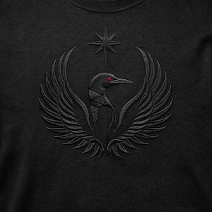 以下が含まれることがあります： 赤い目をした鳥の刺繍デザインが施された黒いスウェットシャツ。翼と星が周りを囲んでいます。デザインは胸の中央に配置されています。スウェットシャツはクルーネックで、テクスチャード加工が施されています。